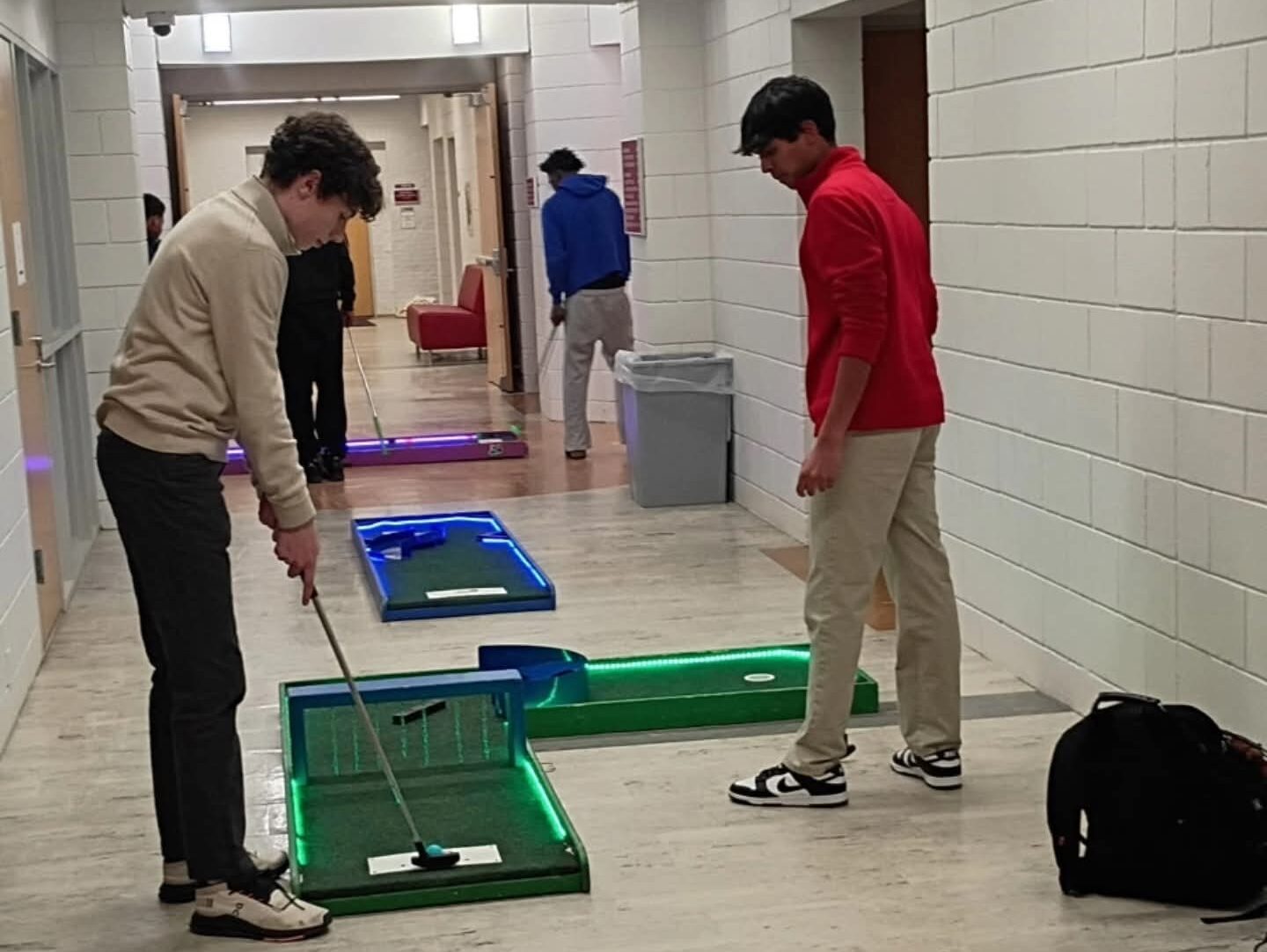 Kids playing on a portable mini golf course set up at a school event