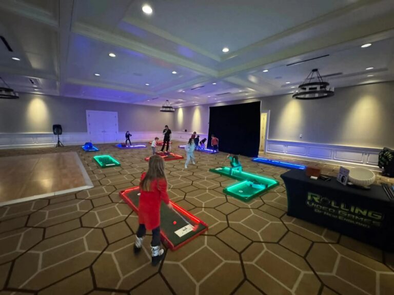 Kids playing on a glowing LED portable mini golf course set up at a Connecticut birthday party event