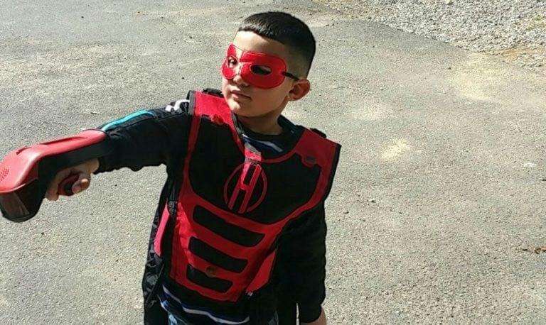 Young boy wearing Hero Blast laser tag equipment with lightweight handheld blaster and red sensor vest during Connecticut birthday party