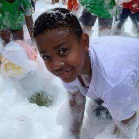 A boy playing in the bubble foam