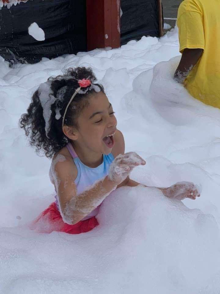 A girl having fun in foams of bubbles