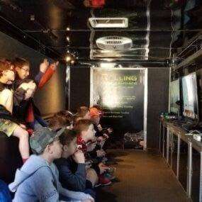 A group of kids playing video games in the truck