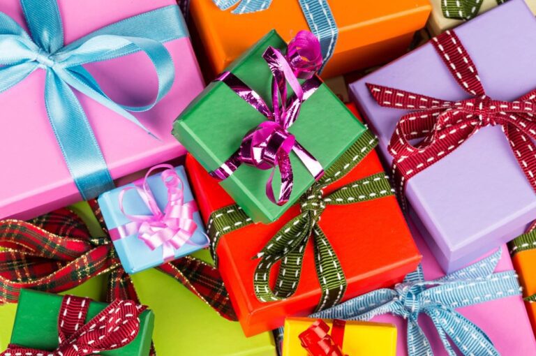 Colorful birthday party gifts stacked on a table with wrapped presents and decorations